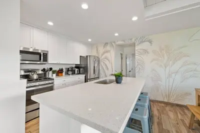 a kitchen with white cabinets and a white counter top at Ocean Views Steps to Beach Rooftop Firepit in San Diego