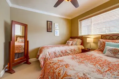 a bedroom with two beds and a ceiling fan at Bayside Gem - Beachfront - Vibrant - Ocean Breeze in San Diego