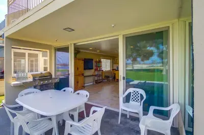 a patio with a white table and chairs on a house at Bayside Gem - Beachfront - Vibrant - Ocean Breeze in San Diego