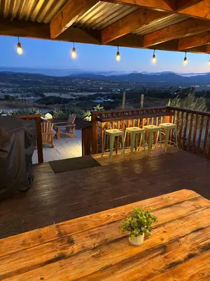 a wooden deck with a table and chairs on it at The Hilltop Haven - Private View Suite in Temecula
