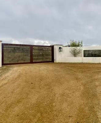 a house with two garage doors and a dirt yard at The Hilltop Haven - Private View Suite in Temecula