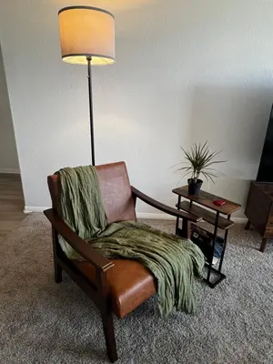 a living room with a chair and a lamp at Cozy Luxurious Spacious Apt with Valley View, Attached Garage,Pool,24-Hour Gym, 3 TV in Mission Viejo