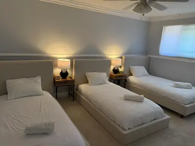 a room with two beds and two lamps and a window at OC Heated Pool,Fire Pit,Spa,BBQ,Disney,Beaches in Mission Viejo