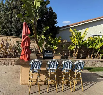 a group of three chairs and a table with an umbrella at OC Heated Pool,Fire Pit,Spa,BBQ,Disney,Beaches in Mission Viejo