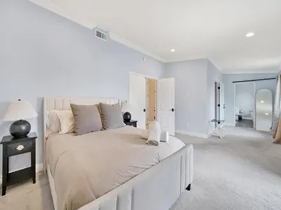a white bedroom with a large bed in a room at OC Heated Pool,Fire Pit,Spa,BBQ,Disney,Beaches in Mission Viejo
