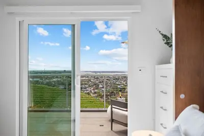 a room with a sliding glass door with a view of a city at Bay View Bungalow in San Diego