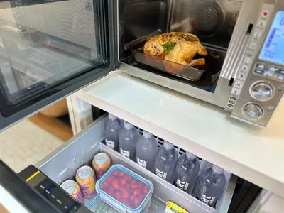 an open refrigerator with a chicken in a tray at Bay View Bungalow in San Diego