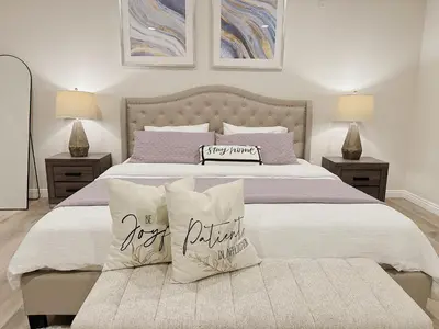 a bedroom with a large bed with two lamps and pillows at \u5c14\u6e7e\u6e29\u99a8\u8212\u9002\u6c11\u5bbf in Irvine