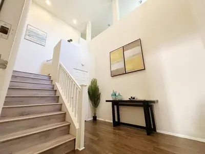 a staircase in a home with white walls and wooden floors at \u5c14\u6e7e\u6e29\u99a8\u8212\u9002\u6c11\u5bbf in Irvine