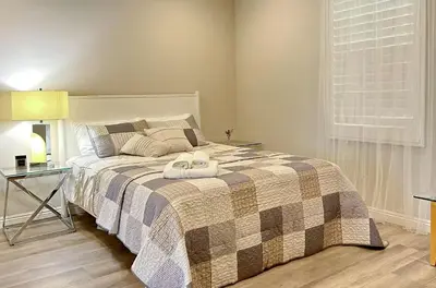 a bedroom with a bed with a blanket and a table at \u6a59\u53bf\u6e29\u99a8\u8212\u9002\u6c11\u5bbf in Irvine