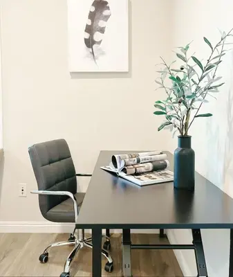 a black table with a vase and a chair at \u6a59\u53bf\u6e29\u99a8\u8212\u9002\u6c11\u5bbf in Irvine