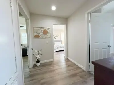 a room with a hallway with white walls and wooden floors at \u6a59\u53bf\u6e29\u99a8\u8212\u9002\u6c11\u5bbf in Irvine