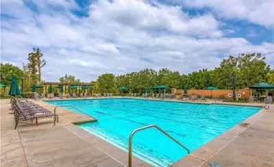 a swimming pool at a resort with chairs and umbrellas at \u6a59\u53bf\u6e29\u99a8\u8212\u9002\u6c11\u5bbf in Irvine