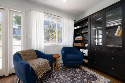 a living room with two blue chairs and a tv at 10 min to Beach Central Villa in San Diego