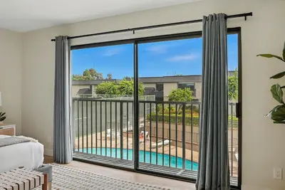 a bedroom with a large window with a view of a pool at Solana Beach Gem - AC and Beach Access in Solana Beach