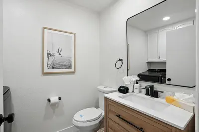 a bathroom with a sink and a toilet and a mirror at Solana Beach Gem - AC and Beach Access in Solana Beach