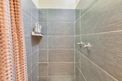 a bathroom with a shower with gray tiles at Extended-Stay Suite Near I-15 in Lake Elsinore! in Lake Elsinore