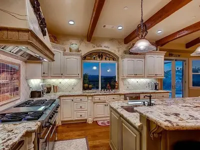 a large kitchen with white cabinets and a large window at La Bella Vista Estate in Fallbrook