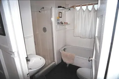 a small bathroom with a toilet and a shower at Mission Beach Cottage in San Diego