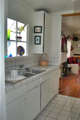 a white kitchen with a sink and a window at Mission Beach Cottage in San Diego