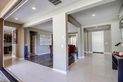 a large living room with white walls and a large mirror at Daydream Palace in Chula Vista