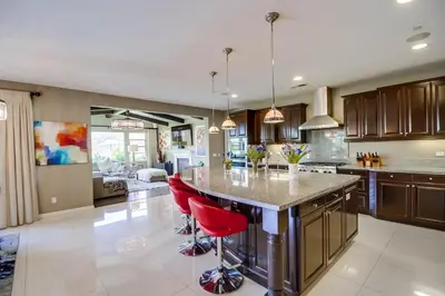 a kitchen with a large island with red bar stools at Daydream Palace in Chula Vista