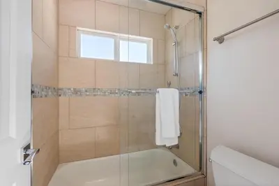 a bathroom with a tub and a shower with a window at Seaside Spiral in San Diego