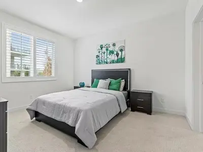 a white bedroom with a large bed with green pillows at Beautiful Irvine Grand Park Community Cozy and Comfortable Home in Irvine