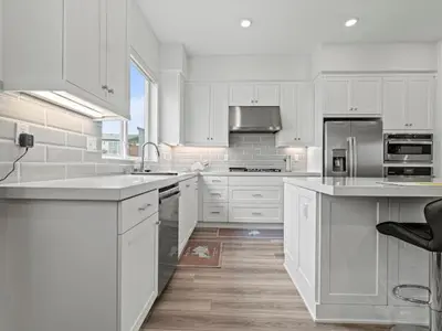 a large white kitchen with white cabinets and appliances at Beautiful Irvine Grand Park Community Cozy and Comfortable Home in Irvine