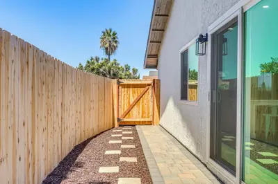 a wooden fence with a wooden gate next to a house at Day Trip to San Diego San Marcos Home Near Hiking in San Marcos