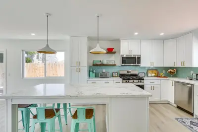 a kitchen with white cabinets and a island with stools at Day Trip to San Diego San Marcos Home Near Hiking in San Marcos