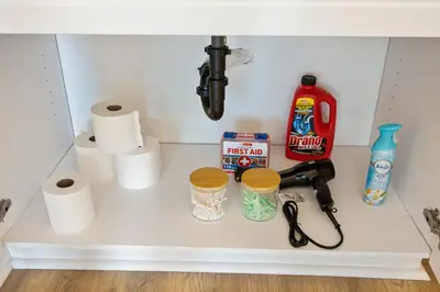 a shelf under a sink with toilet paper at LUX Oasis North Park, King Beds, Workspaces, Parking in San Diego