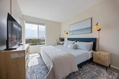 a bedroom with a large bed and a flat screen tv at LUX Oasis North Park, King Beds, Workspaces, Parking in San Diego