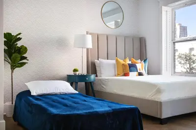 a bedroom with a large bed and a mirror at The Historic Penn Hotel in San Diego