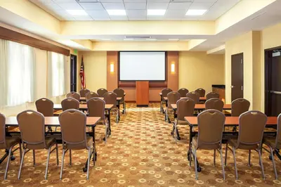 a conference room with tables and chairs and a screen at Hyatt Place San Diego-Vista/Carlsbad in Vista