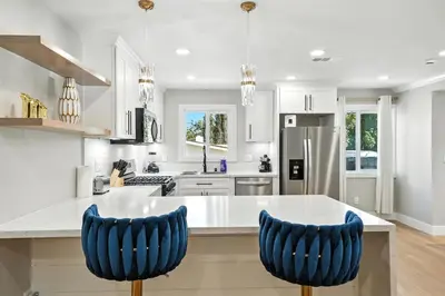 a kitchen with white cabinets and blue bar stools at Xlnc Exotic Home Witt Rd Poway in Poway