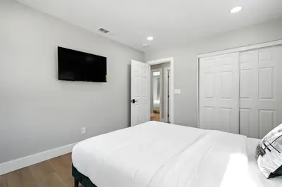 a white bedroom with a bed and a flat screen tv at Xlnc Exotic Home Witt Rd Poway in Poway