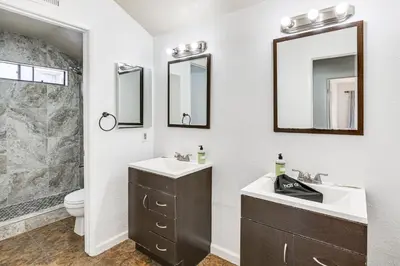 a bathroom with a sink and a toilet and mirror at Spacious Getaway with Pool and Spa in La Mesa! in La Mesa