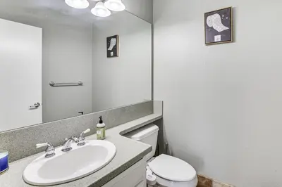 a bathroom with a sink and a toilet and a mirror at Spacious Getaway with Pool and Spa in La Mesa! in La Mesa