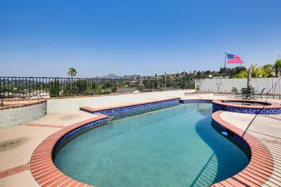 a swimming pool with blue water and red bricks at Spacious Getaway with Pool and Spa in La Mesa! in La Mesa