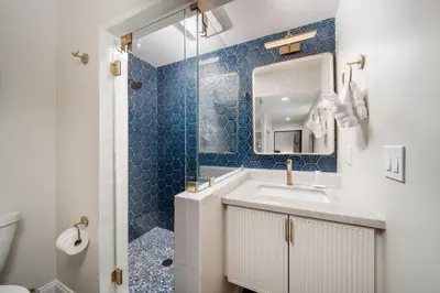 a bathroom with a sink and a mirror and a shower at Luxury Point Loma Retreat Pool Spa Views in San Diego