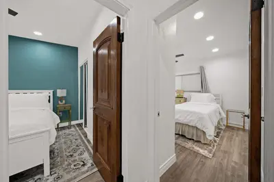 a bedroom with a bed with white sheets and blue walls at 2br Pet-Friendly Oceanside Home in Oceanside