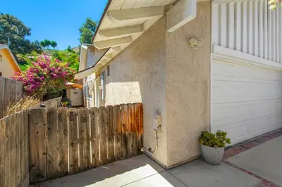 a wooden fence next to a house with a garage at Relax Explore from Mission Viejo Pool Spa in Mission Viejo