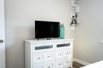 a white dresser with a television on top of it at Beach Home in Quiet Neighborhood 5 minutes from the Pier in Oceanside
