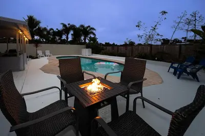 a patio with a fire table and chairs next to a pool at Beach Home in Quiet Neighborhood 5 minutes from the Pier in Oceanside