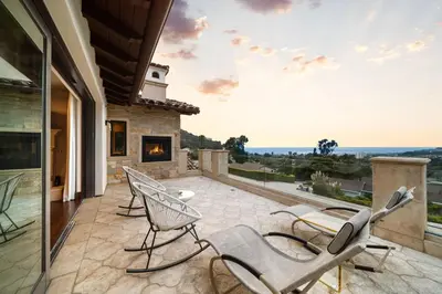 a patio with chairs and a fireplace on a house at Elegant La Jolla Villa - Ocean Views & Pool in San Diego