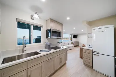 a kitchen with a sink and a white refrigerator at New Modern Studio - Stunning Ocean view in San Diego
