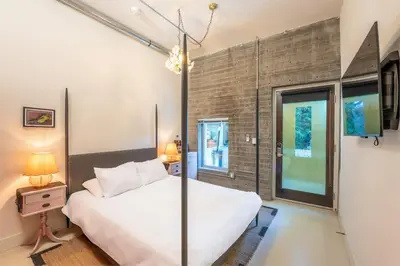 a bedroom with a white bed and a large window at Hotel Narcissus - Room 1 in San Diego