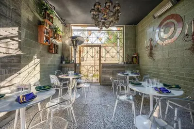 a room with white tables and chairs and a window at Hotel Narcissus - Room 2 in San Diego