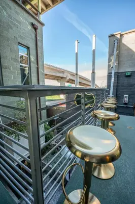 a row of tables and stools on a balcony at Hotel Narcissus - Room 2 in San Diego